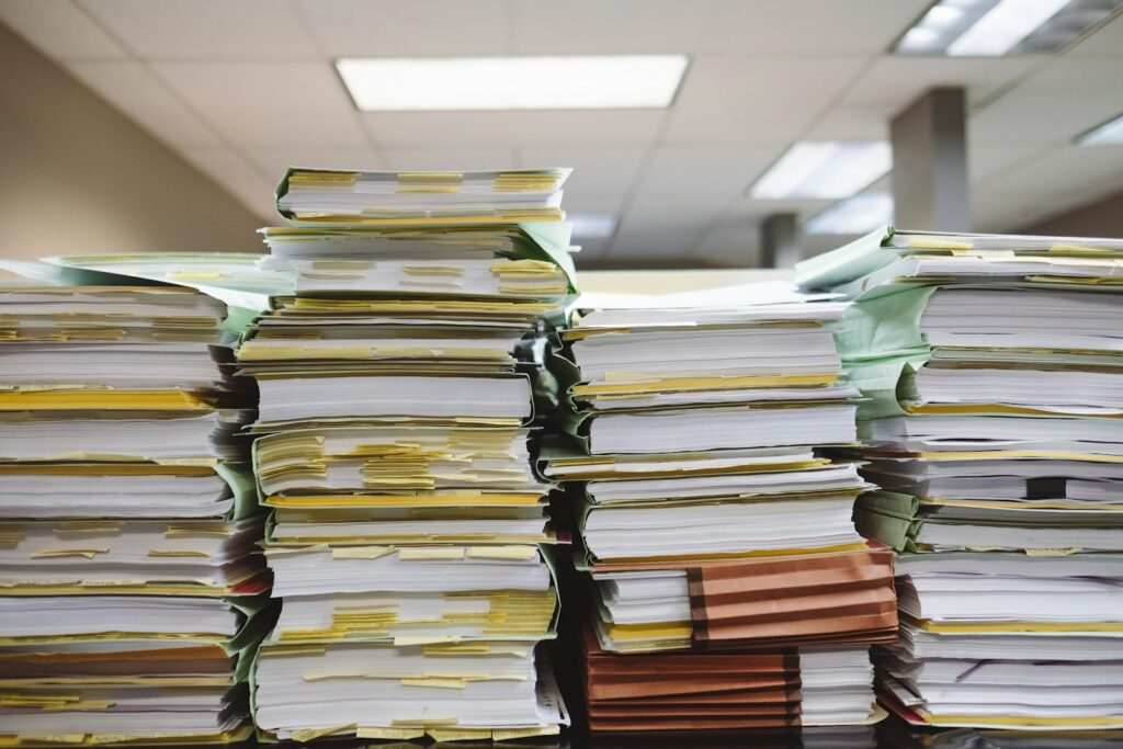 Pilhas de documentos e pastas de arquivo, simbolizando o RAG caseiro com documentos próprios numa IA